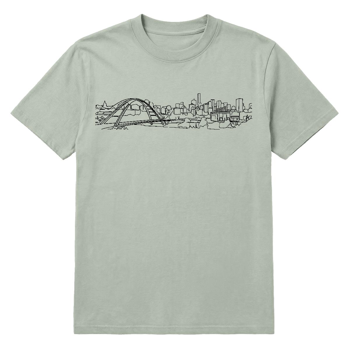 E-Town Tee — the Edmonton skyline and Walterdale Bridge in one continuous line, on a bay garment-dyed heavyweight tee