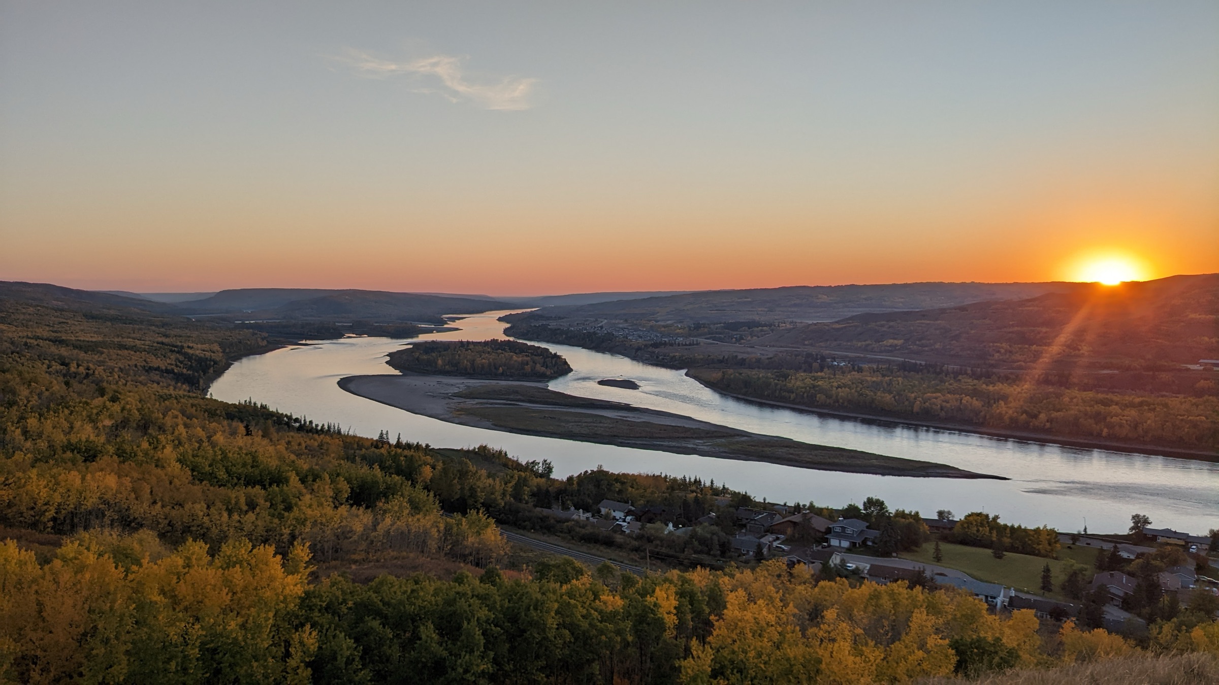 Sunset over the Peace River valley in autumn — the river winding toward the last light